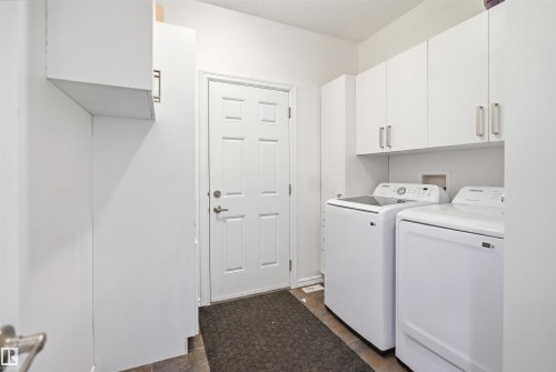 Dedicated laundry area featuring white cabinetry, a built-in storage unit, and tile flooring - 1523 36 Avenue, Edmonton, AB - Indoor Photo Showing Laundry Room
