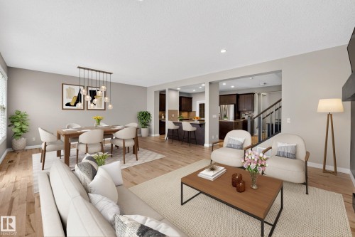 Open-concept living space featuring wood-finish flooring throughout, a dining area with a linear pendant light fixture, and recessed lighting - 17838 60A Street, Edmonton, AB - Indoor Photo Showing Living Room