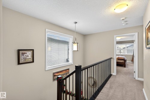 Second-story hallway featuring neutral paint, carpeted flooring, and a white trim window with blinds - 17838 60A Street, Edmonton, AB - Indoor Photo Showing Other Room