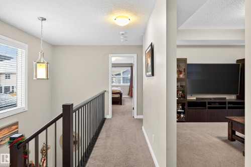 Hallway featuring carpet flooring, neutral painted walls, and a contemporary pendant light fixture - 17838 60A Street, Edmonton, AB - Indoor Photo Showing Other Room