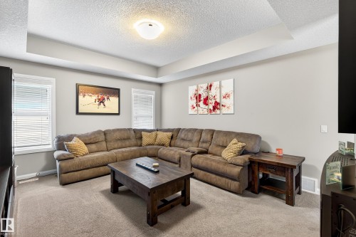 Spacious common area featuring a tray ceiling, recessed lighting, and soft gray wall tones - 17838 60A Street, Edmonton, AB - Indoor Photo Showing Living Room