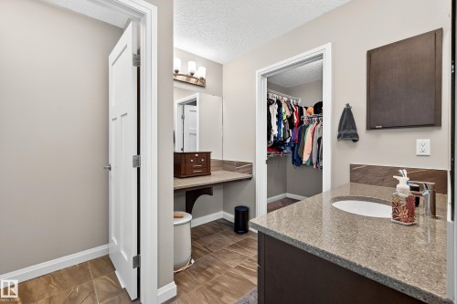 Spacious vanity featuring a light-toned countertop, undermount sink, and modern faucet - 17838 60A Street, Edmonton, AB - Indoor