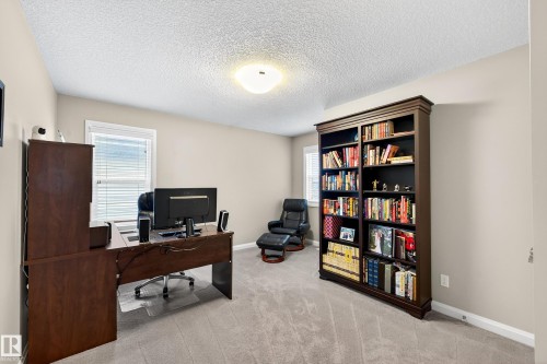Spacious room featuring neutral wall tones, textured ceiling, and light gray carpeting - 17838 60A Street, Edmonton, AB - Indoor Photo Showing Office
