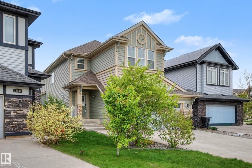 Two-story home with light blue siding and a prominent gabled roofline featuring decorative trim - 17838 60A Street, Edmonton, AB - Outdoor