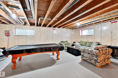 Finished basement space featuring exposed wood beams and utility conduits - 17838 60A Street, Edmonton, AB - Indoor Photo Showing Basement