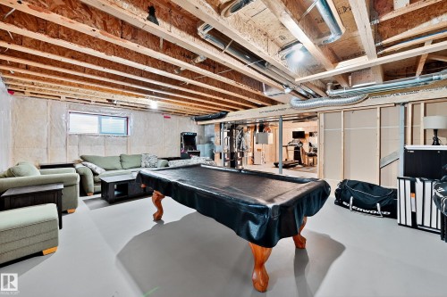 Expansive unfinished basement featuring exposed ceiling joists and ductwork, a small rectangular window, and insulated walls - 17838 60A Street, Edmonton, AB - Indoor Photo Showing Basement