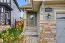 Exterior entry featuring stacked stone accents, horizontal siding, a covered porch, and a light-paneled front door - 17838 60A Street, Edmonton, AB  - Outdoor 