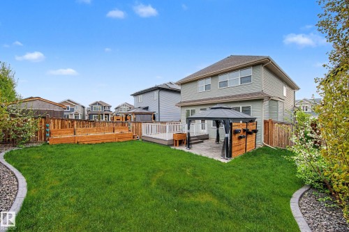 Expansive backyard featuring a lush lawn, decorative stone border, and a privacy fence - 17838 60A Street, Edmonton, AB - Outdoor With Deck Patio Veranda