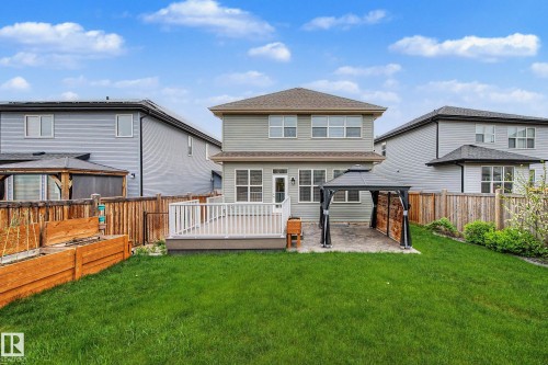 Spacious backyard featuring a composite deck with white railings, a paved patio area, and a large lawn - 17838 60A Street, Edmonton, AB - Outdoor With Deck Patio Veranda