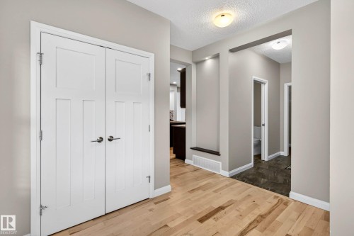 Entryway featuring light wood-finish flooring, white trim, and a recessed wall niche with accent lighting - 17838 60A Street, Edmonton, AB - Indoor Photo Showing Other Room