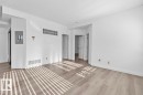 Spacious room featuring wood-finish flooring, white walls, and bright overhead lighting - 117 10717 83 Avenue, Edmonton, AB  - Indoor Photo Showing Other Room 