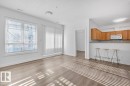 Open-concept living area featuring wood-finish flooring, white walls, and recessed lighting - 117 10717 83 Avenue, Edmonton, AB  - Indoor 