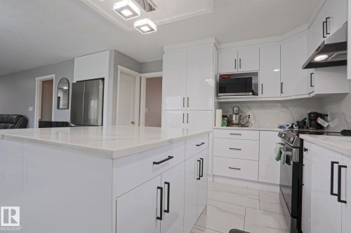 Sleek kitchen island featuring a light-toned countertop - 313 Jillings Crescent, Edmonton, AB - Indoor Photo Showing Kitchen