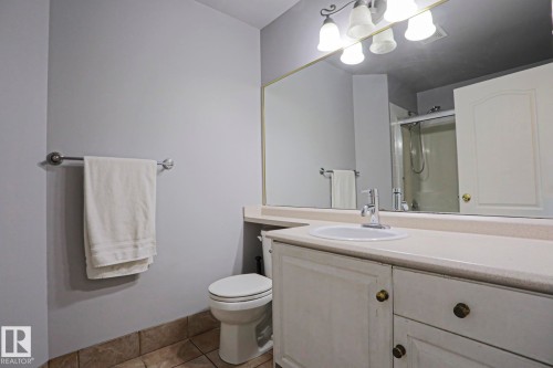 Bathroom vanity with an integrated sink, polished chrome faucet, and expansive wall-mounted mirror - 313 Jillings Crescent, Edmonton, AB - Indoor Photo Showing Bathroom