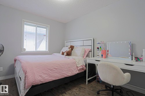 Room featuring wood-finish flooring, a white-framed window with blinds, and light gray painted walls - 313 Jillings Crescent, Edmonton, AB - Indoor Photo Showing Bedroom