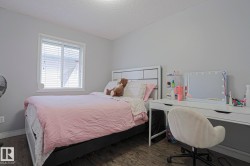 Room featuring wood-finish flooring, a white-framed window with blinds, and light gray painted walls - 