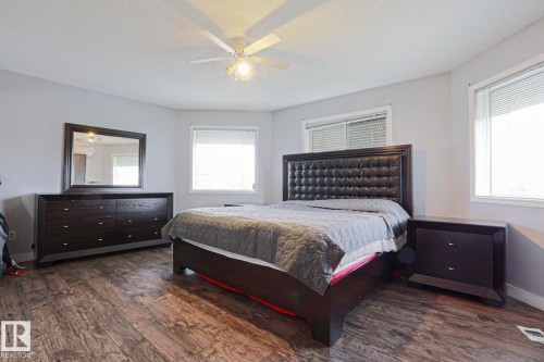 Spacious room featuring wood-finish flooring, light grey walls, and a ceiling fan with integrated lighting - 313 Jillings Crescent, Edmonton, AB - Indoor Photo Showing Bedroom