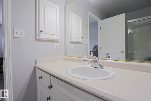 Vanity featuring a white basin sink with a chrome faucet set within a light-toned countertop - 313 Jillings Crescent, Edmonton, AB - Indoor Photo Showing Bathroom