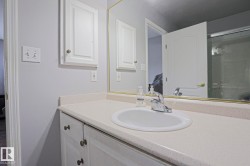 Vanity featuring a white basin sink with a chrome faucet set within a light-toned countertop - 