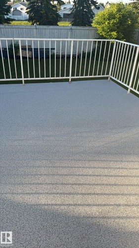 Expansive outdoor deck featuring a textured grey surface and white metal railings - 313 Jillings Crescent Nw, Edmonton, AB - Outdoor