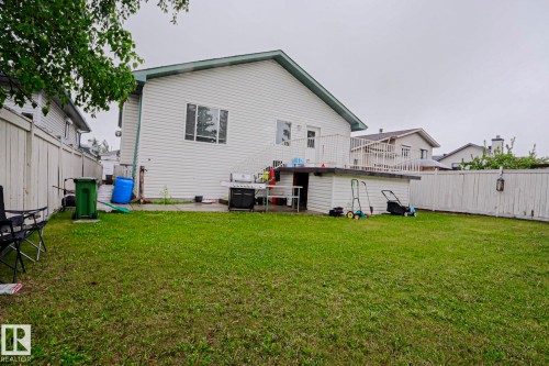 Spacious grass yard surrounding a white siding home - 313 Jillings Crescent, Edmonton, AB - Outdoor With Exterior
