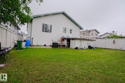 Spacious grass yard surrounding a white siding home - 
