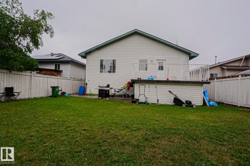 Expansive backyard with a manicured lawn, full perimeter privacy fencing, and a raised exterior deck - 313 Jillings Crescent, Edmonton, AB - Outdoor