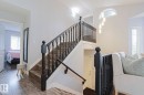 Wood-finish flooring throughout, complemented by a dark wood staircase with white risers and balusters - 313 Jillings Crescent, Edmonton, AB  - Indoor Photo Showing Other Room 