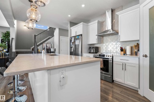 Contemporary kitchen featuring a spacious island with stone countertops and an undermount sink - 524 Mcdonough Way, Edmonton, AB - Indoor Photo Showing Kitchen With Upgraded Kitchen