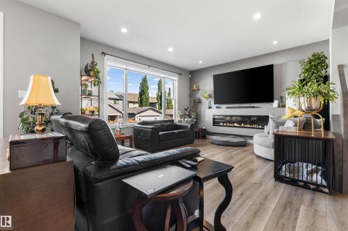 Living area featuring wood-finish flooring, recessed lighting, and a linear electric fireplace with a white surround - 524 Mcdonough Way, Edmonton, AB - Indoor Photo Showing Living Room