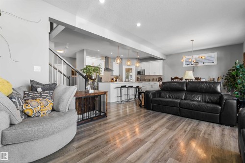 Open-concept living area with wood-finish flooring, recessed lighting, and a light-grey wall palette - 524 Mcdonough Way, Edmonton, AB - Indoor Photo Showing Living Room