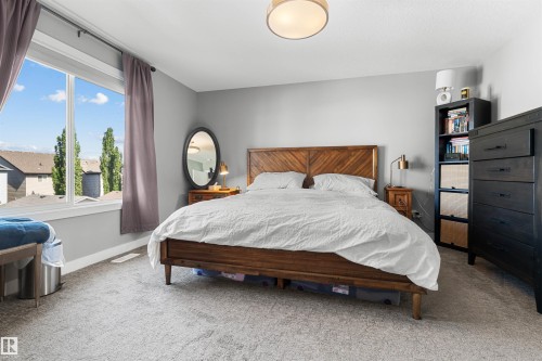 Spacious room with a large window, light gray wall paint, and neutral carpet flooring - 524 Mcdonough Way, Edmonton, AB - Indoor Photo Showing Bedroom