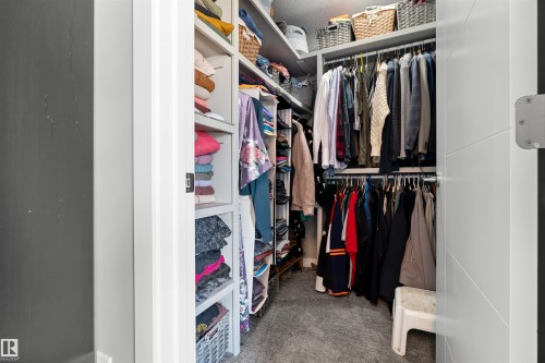 Custom closet system featuring built-in shelving, multiple hanging rods, and integrated storage solutions - 524 Mcdonough Way, Edmonton, AB - Indoor With Storage