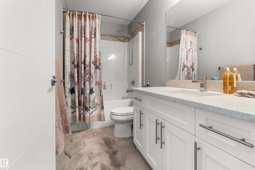 Bathroom featuring a white vanity with double sinks, light-toned countertop, and a full-width mirror - 524 Mcdonough Way, Edmonton, AB - Indoor Photo Showing Bathroom