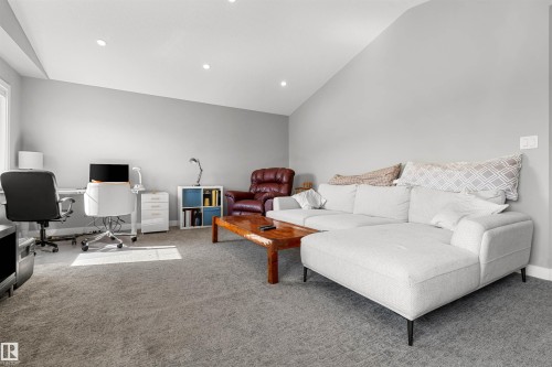 Spacious room featuring sloped ceilings, recessed lighting, and soft gray carpeting - 524 Mcdonough Way, Edmonton, AB - Indoor