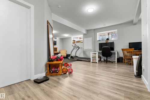 Spacious room featuring light wood-finish flooring, recessed lighting, and a white interior door - 524 Mcdonough Way, Edmonton, AB - Indoor