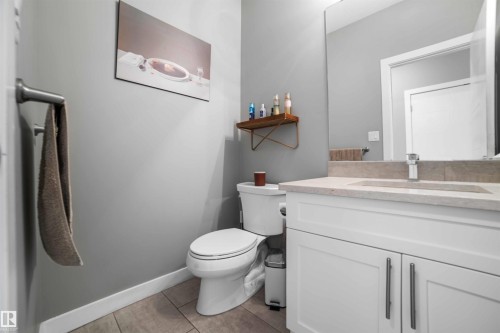 Bathroom featuring a white vanity with a stone-finish countertop, undermount sink, and chrome faucet - 524 Mcdonough Way, Edmonton, AB - Indoor Photo Showing Bathroom