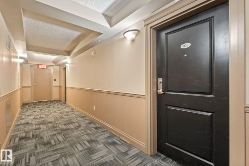 Entry door featuring a panel design and brushed nickel hardware - 905 10303 105 Street Nw, Edmonton, AB - Indoor Photo Showing Other Room