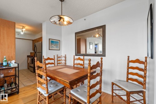 Dining area featuring wood-finish flooring and a contemporary pendant light fixture - 905 10303 105 Street Nw, Edmonton, AB - Indoor Photo Showing Dining Room