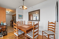Dining area featuring wood-finish flooring and a contemporary pendant light fixture - 
