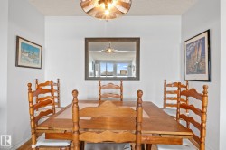 Dedicated dining area featuring light-toned wood-finish flooring and a contemporary overhead light fixture - 