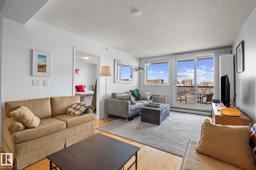 Living area featuring light wood-finish flooring, white walls, and a light-colored area rug - 905 10303 105 Street Nw, Edmonton, AB - Indoor Photo Showing Living Room