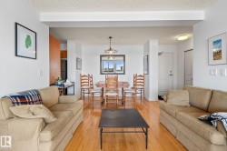 Expansive living area featuring wood-finish flooring, a dining area, and a kitchen pass-through - 