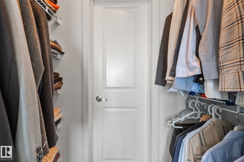 Walk-in closet featuring white wire shelving, hanging rods, and a paneled door with a silver-tone knob - 905 10303 105 Street Nw, Edmonton, AB - Indoor With Storage