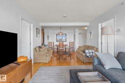 Expansive living area featuring wood-finish flooring, light-colored walls, and recessed lighting - 