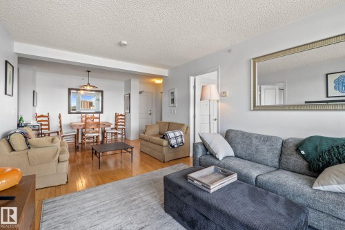 Open-concept living and dining area featuring wood-finish flooring, neutral wall tones, and recessed lighting - 905 10303 105 Street Nw, Edmonton, AB - Indoor Photo Showing Living Room