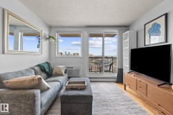 Living area featuring wood-finish flooring, a wall-mounted AC unit, and a sliding glass door to a balcony - 