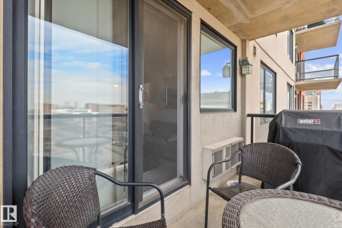 Private balcony featuring a sliding glass door entry, exterior wall sconce, and a glass panel railing - 905 10303 105 Street Nw, Edmonton, AB -  With Balcony With Exterior