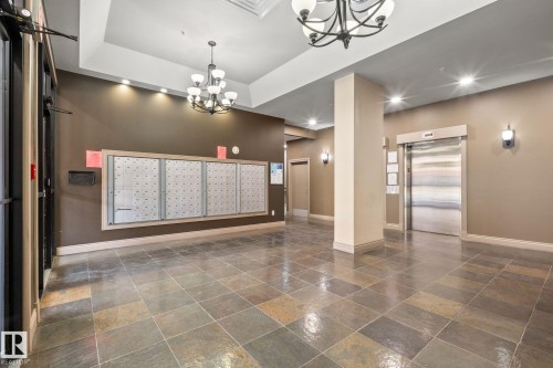 Lobby with multi-toned tile flooring, recessed lighting, and two chandeliers - 905 10303 105 Street Nw, Edmonton, AB - Indoor Photo Showing Other Room