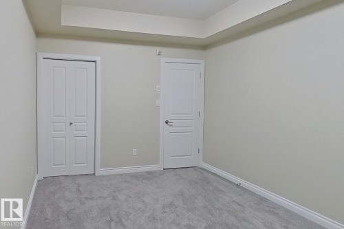 Neutral wall tones with tray ceiling detail - 108 9603 98 Avenue Nw, Edmonton, AB - Indoor Photo Showing Other Room